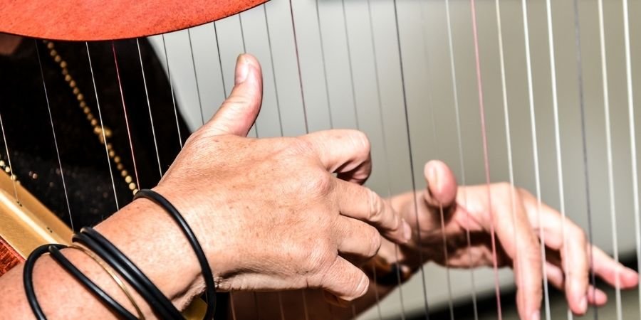 Joven tocando un arpa irlandesa